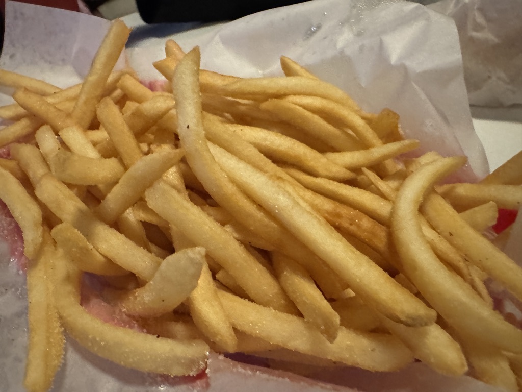 A paper-lined basket of golden French fries